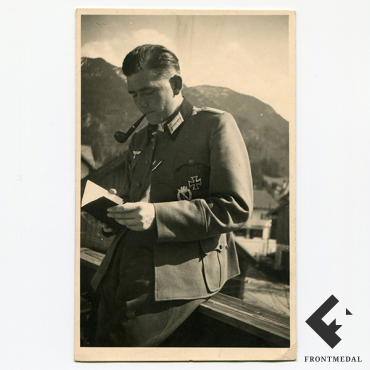 Офицер пехоты Вермахта на отдыхе с трубкой за чтением книги